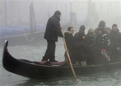 Gondoleiro conduz passageiros pelo Grande Canal de Veneza, na Itália