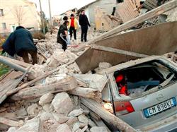 Carro é enterrado sob os escombros de edifícios atingidos pelo terremoto, em Onna