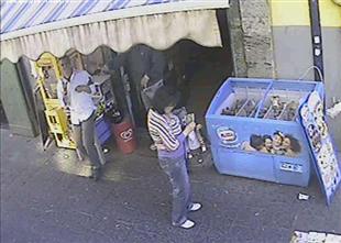 Imagem retirada do vídeo mostra a vítima, de camisa branca, o suspeito e mulher que conferia loteria