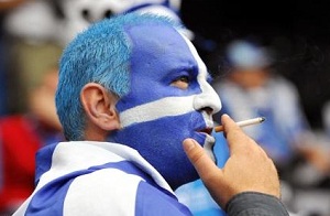 Torcedor grego fumando em estádio na Itália